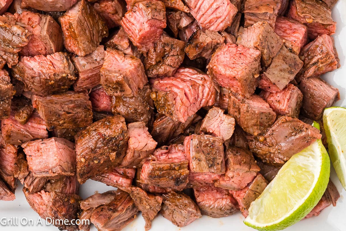 Chipotle Steak Bites on a platter with a lime wedge on the side
