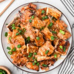 Teriyaki Salmon Bites on a plate topped with sesame seeds and chopped green onions