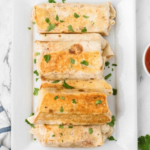 Easy breakfast burrito on a white plate.
