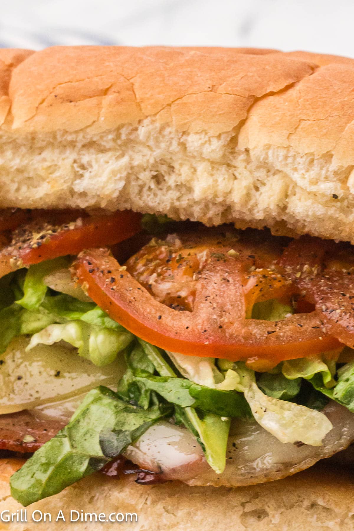 Slice tomatoes, shredded lettuce, deli meat on a hoagie rolls