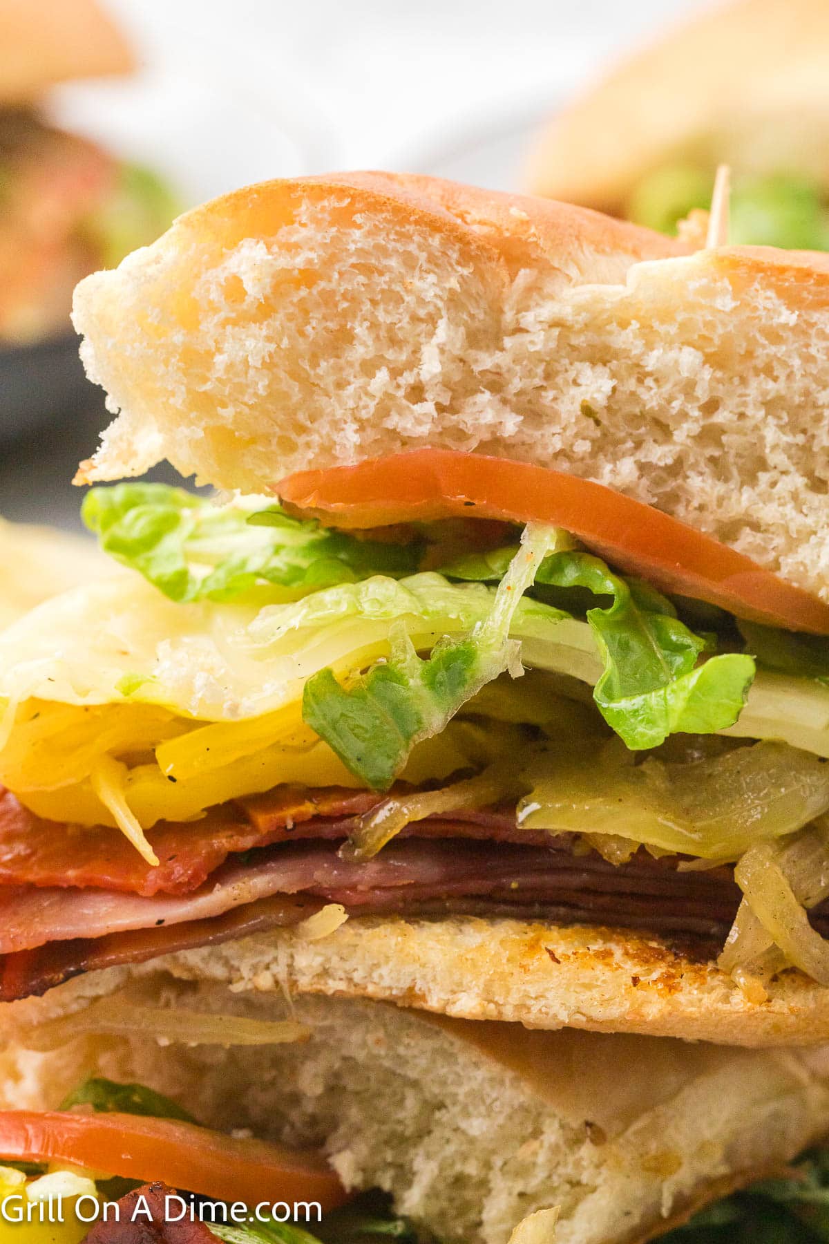 Italian Subs that are made with deli meat, grilled peppers and onions with slice tomato on a hoagie bun