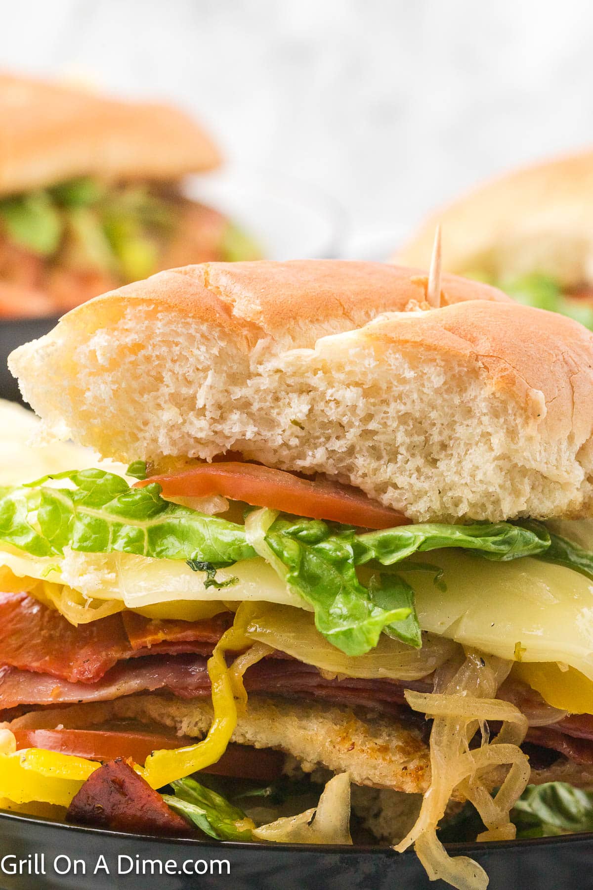 Italian Subs layered with lettuce, slice cheese, deli meat with a toasted hoagie bun