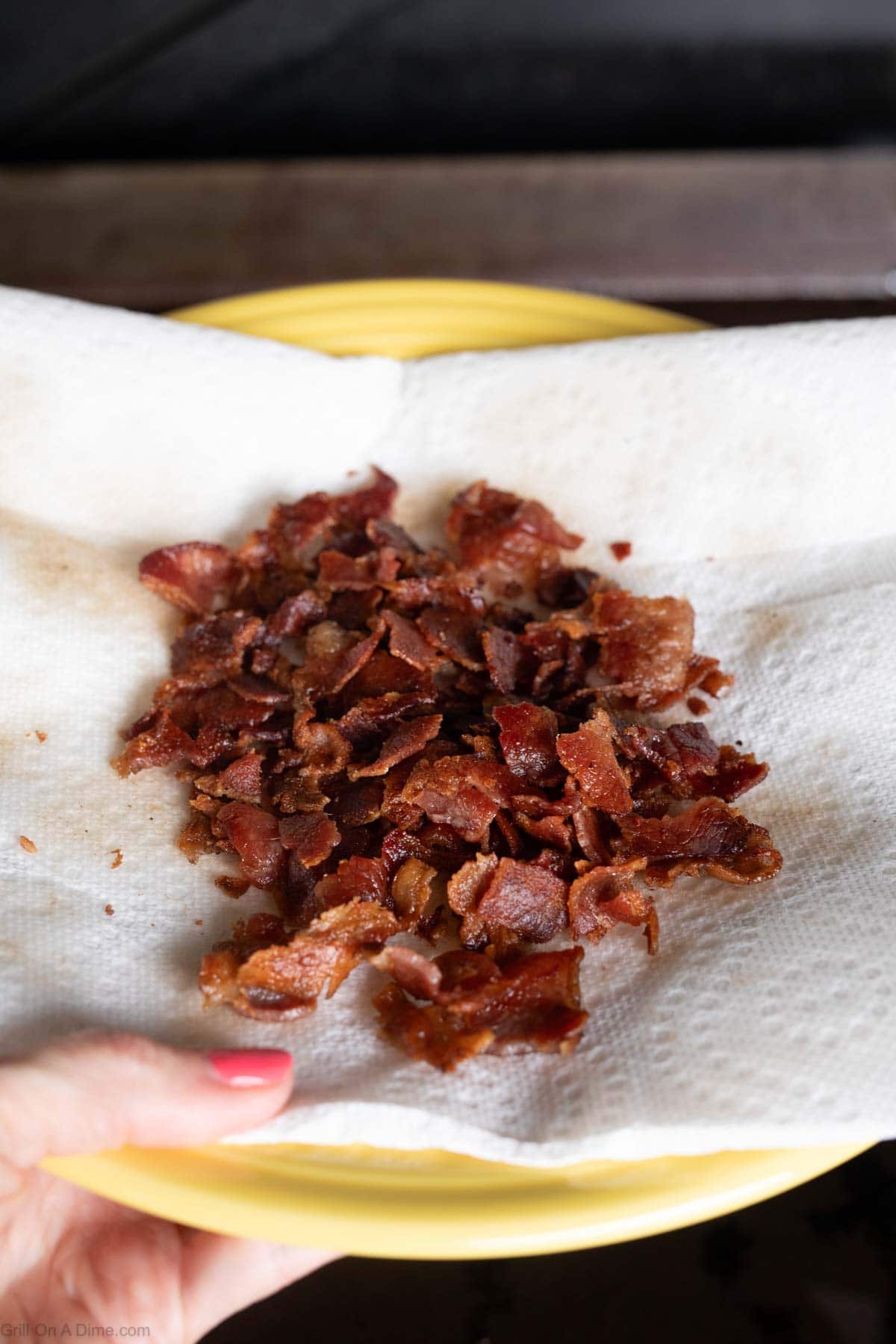 Chopped crispy bacon on a paper towel on a plate