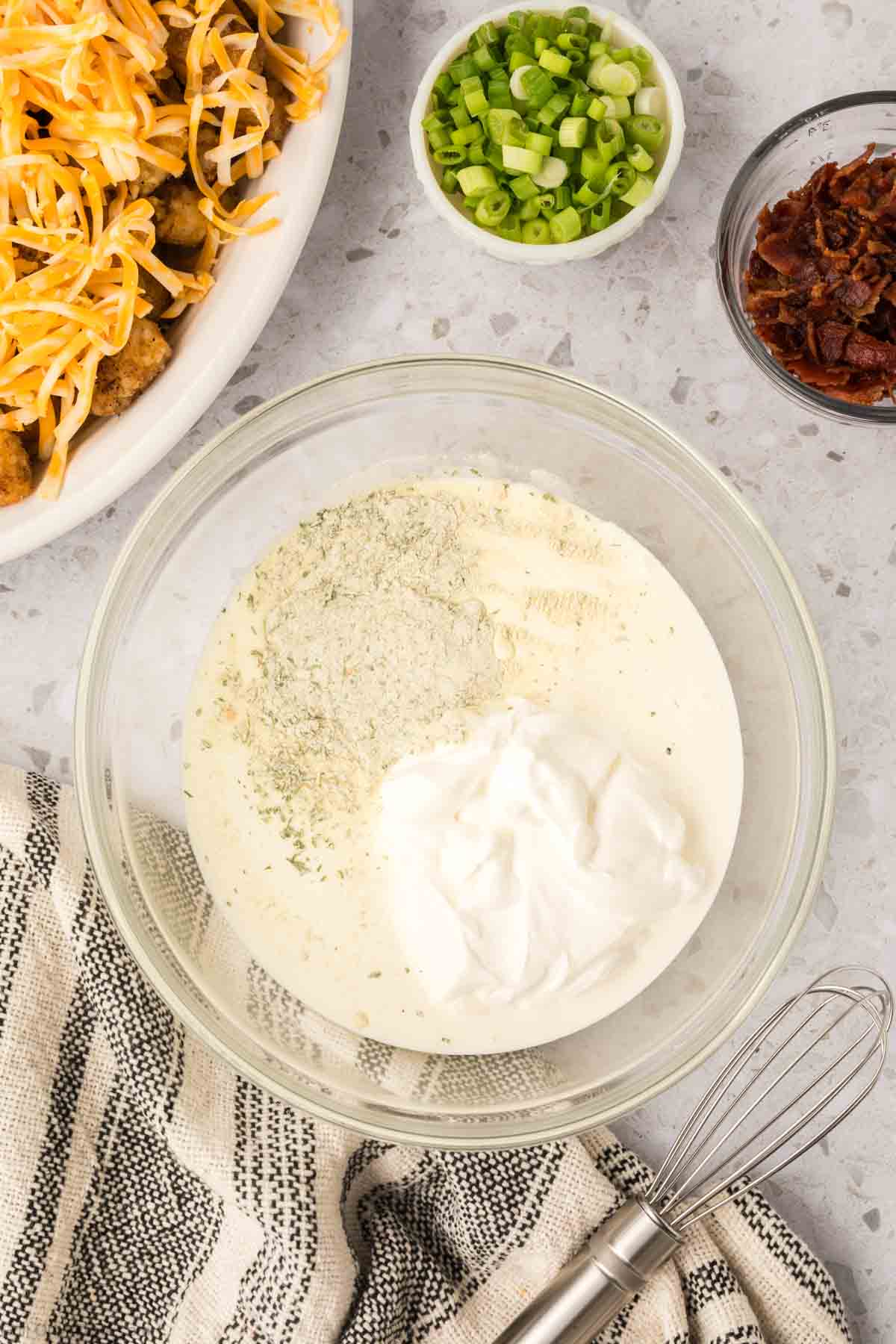 Combining the milk, ranch seasoning and sour cream in a bowl