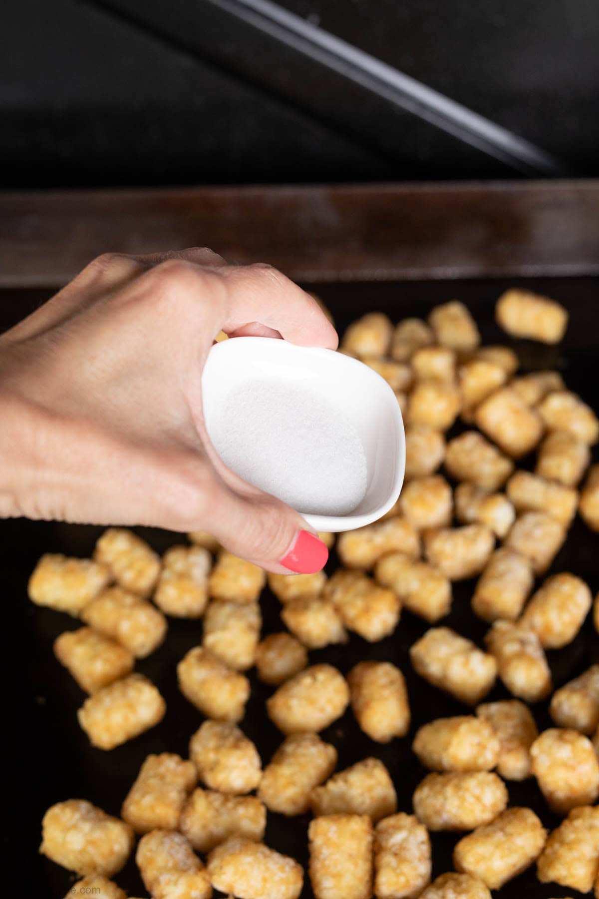 Sprinkle salt on the tots on the griddle