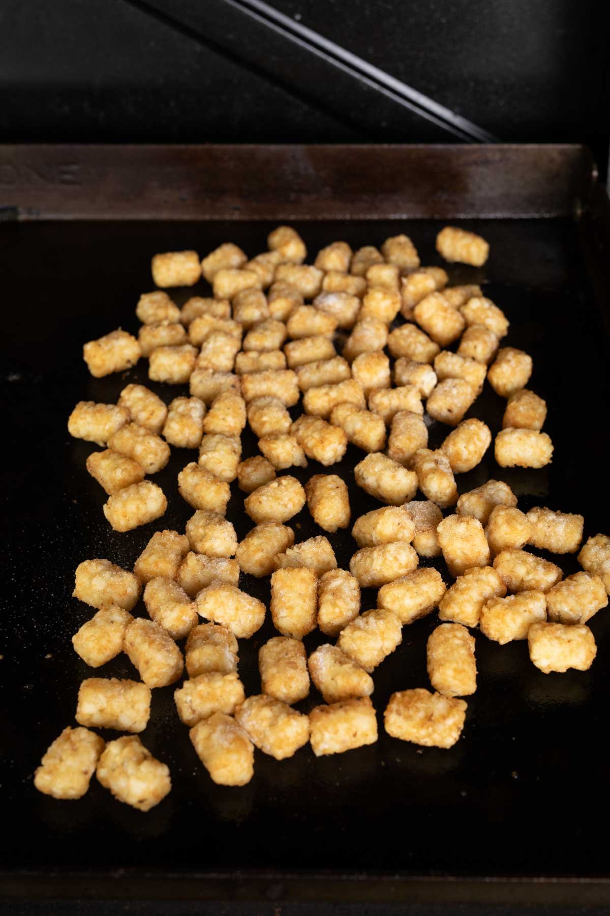 Placing the tots on the Blackstone Griddle