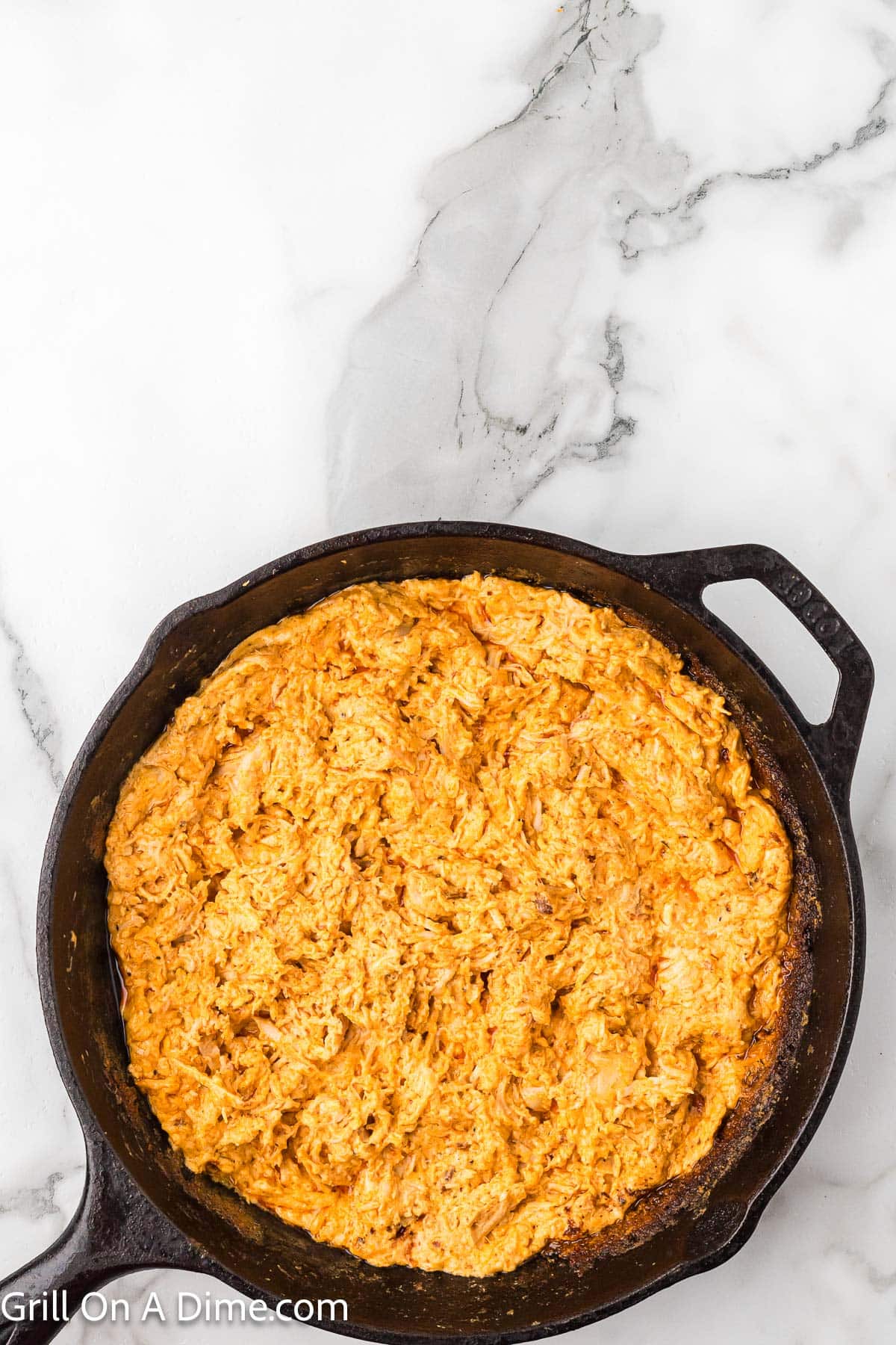 Smoked buffalo chicken dip in a cast iron skillet