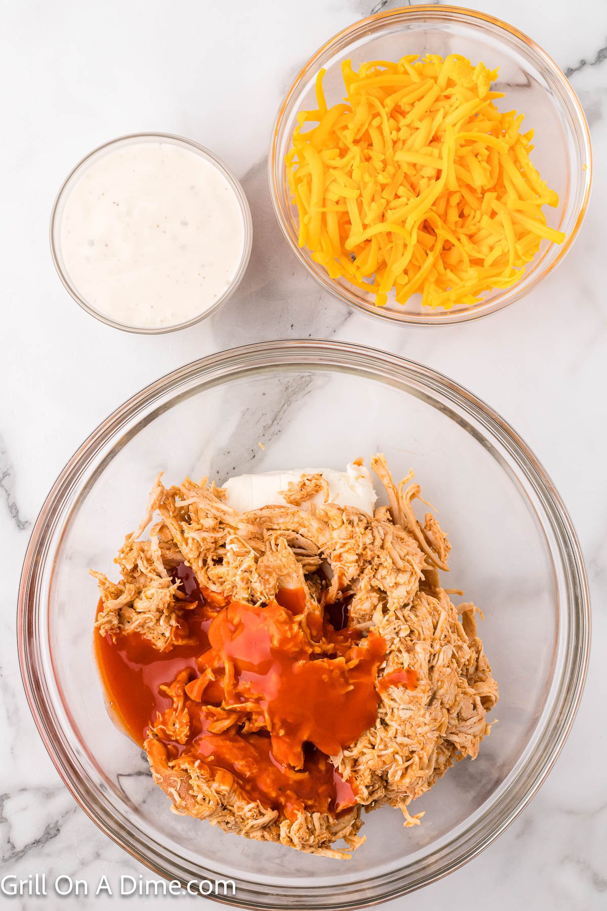 Combining the buffalo chicken dip ingredients in a bowl
