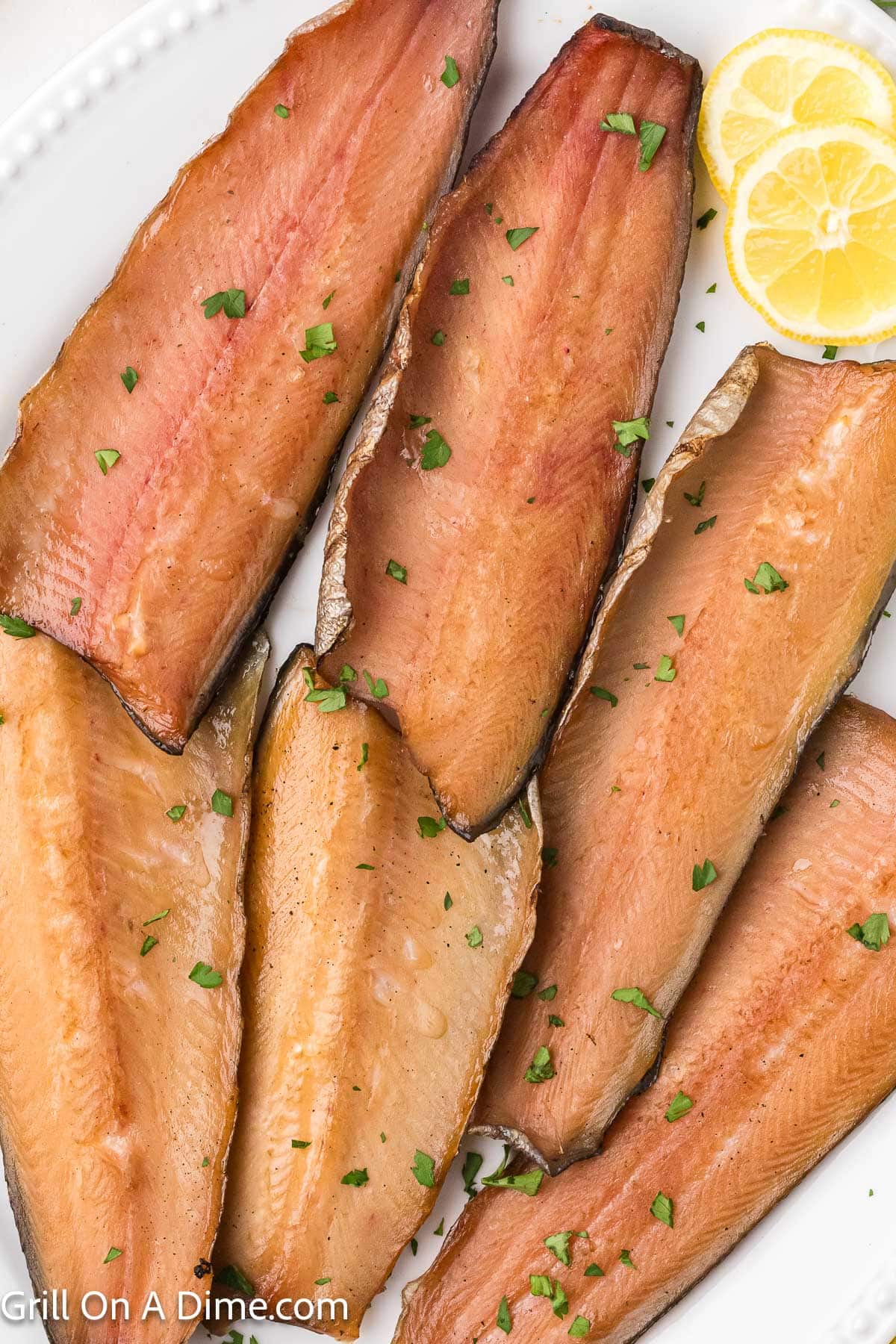 Smoked Trout Fillets placed on a serving platter with lemon slices