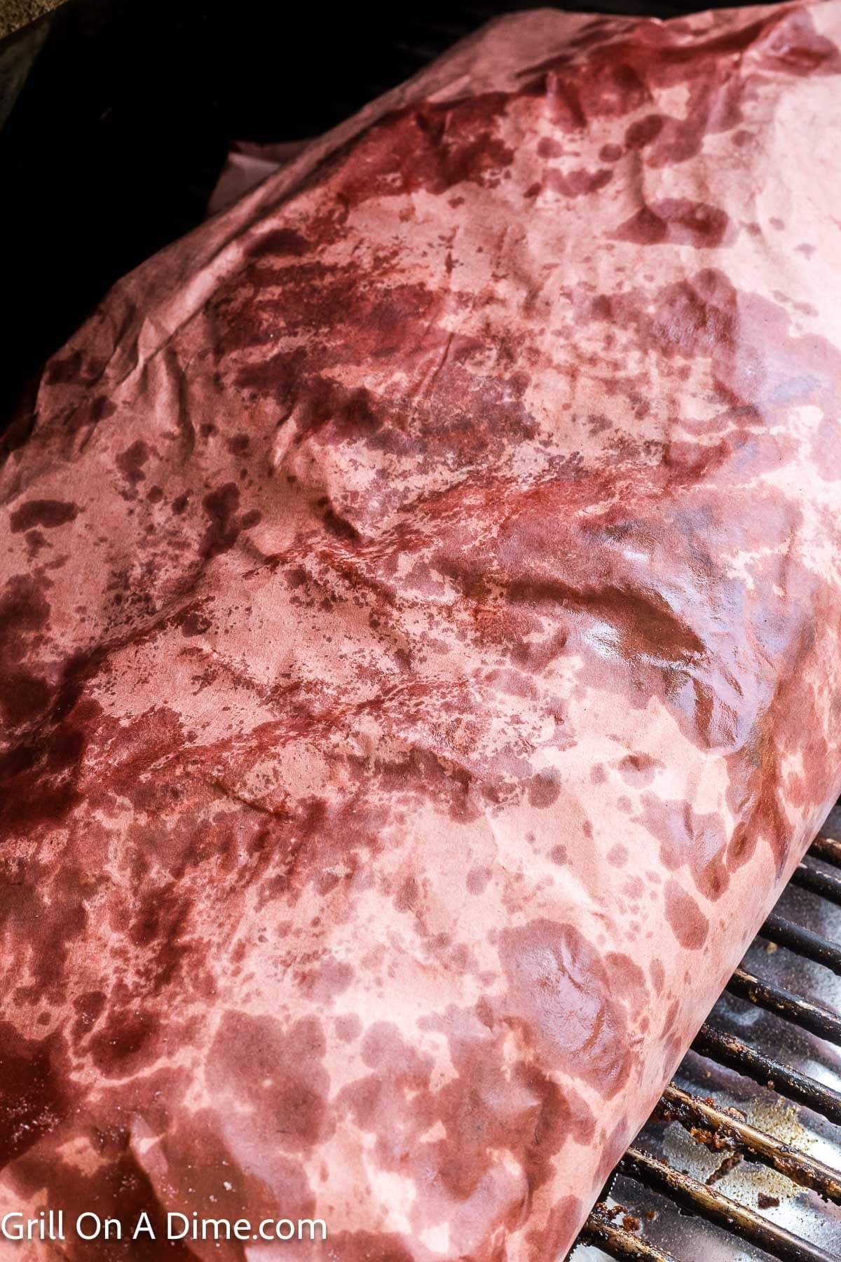 Wrapped brisket on the grill grates in the smoker