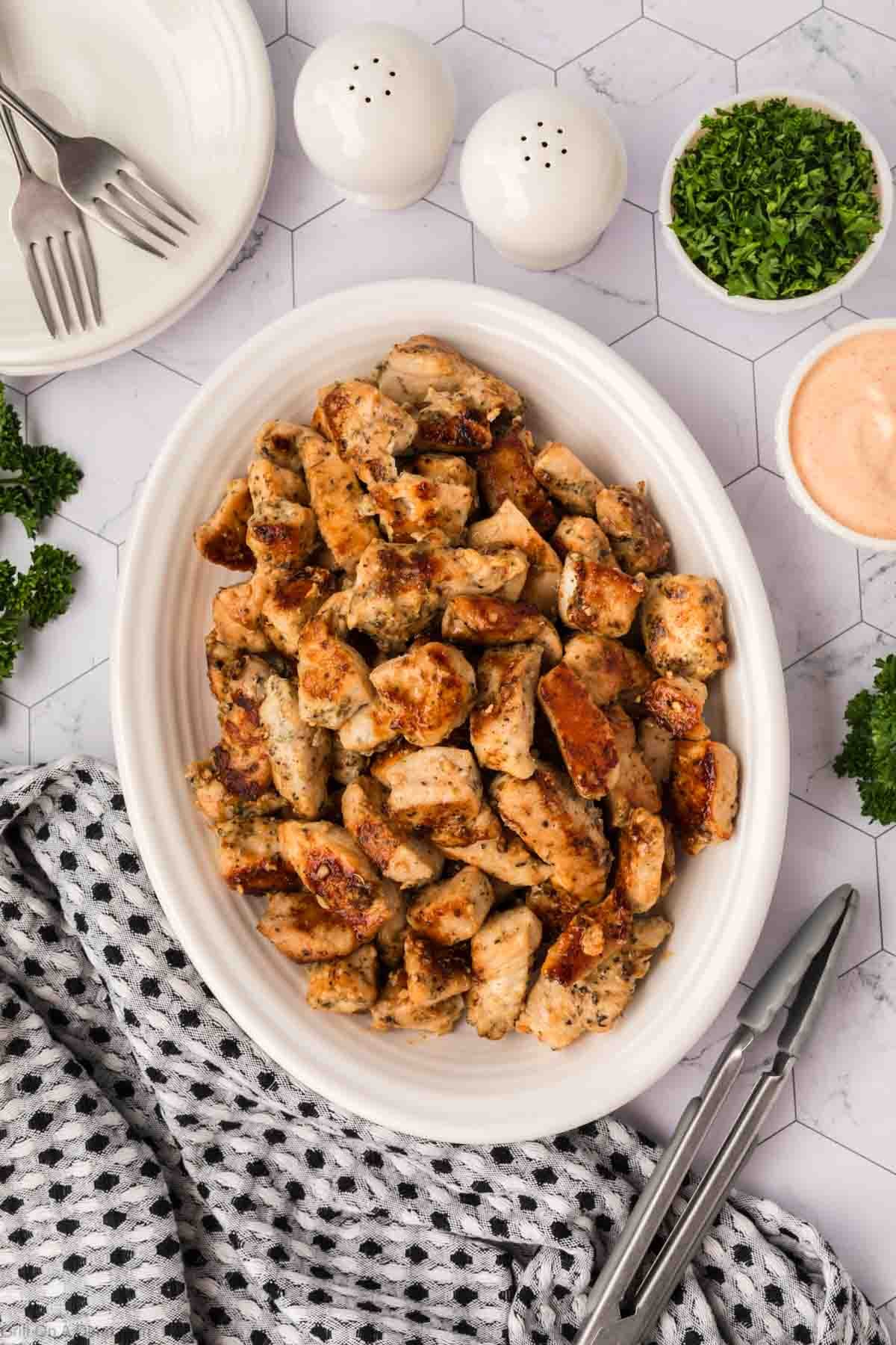 Cooked chicken bites on a white platter