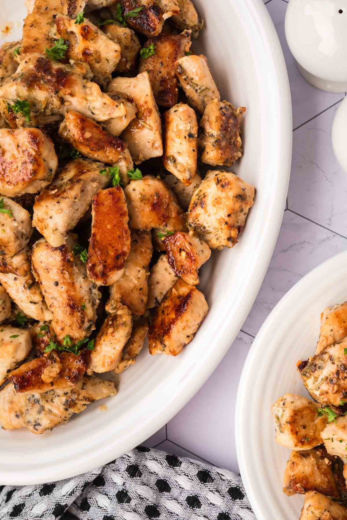 Golden brown chicken bites on a white platter