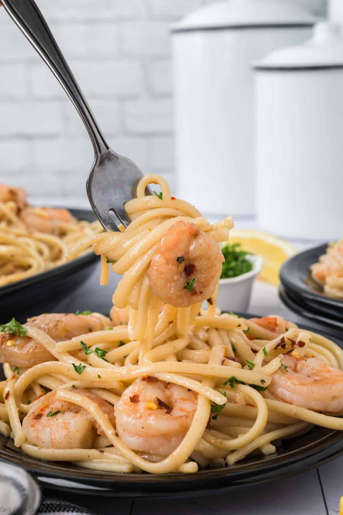 Shrimp Scampi on a plate with a bite on a fork