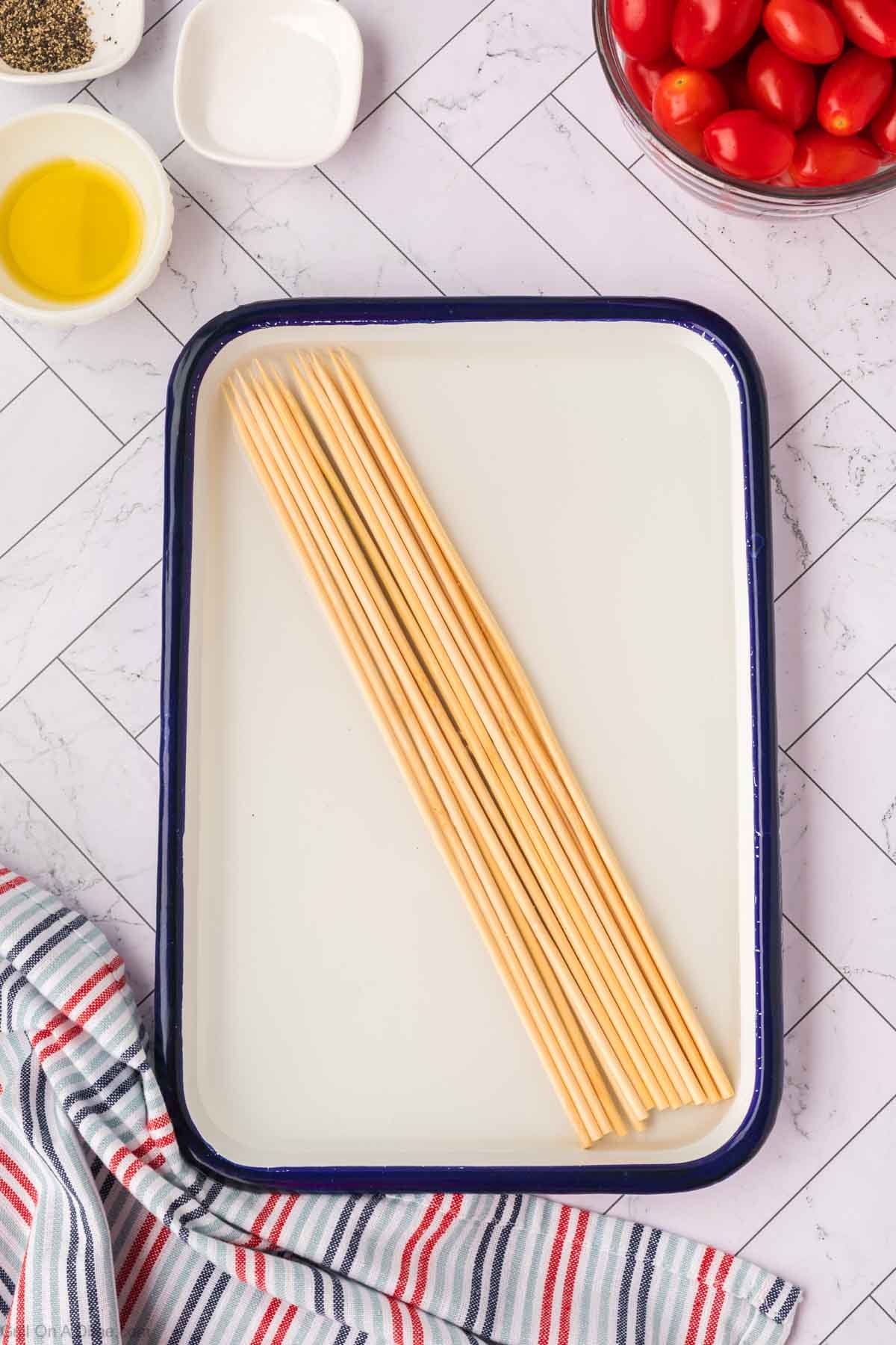 Soaking wooden skewers in a pan in water
