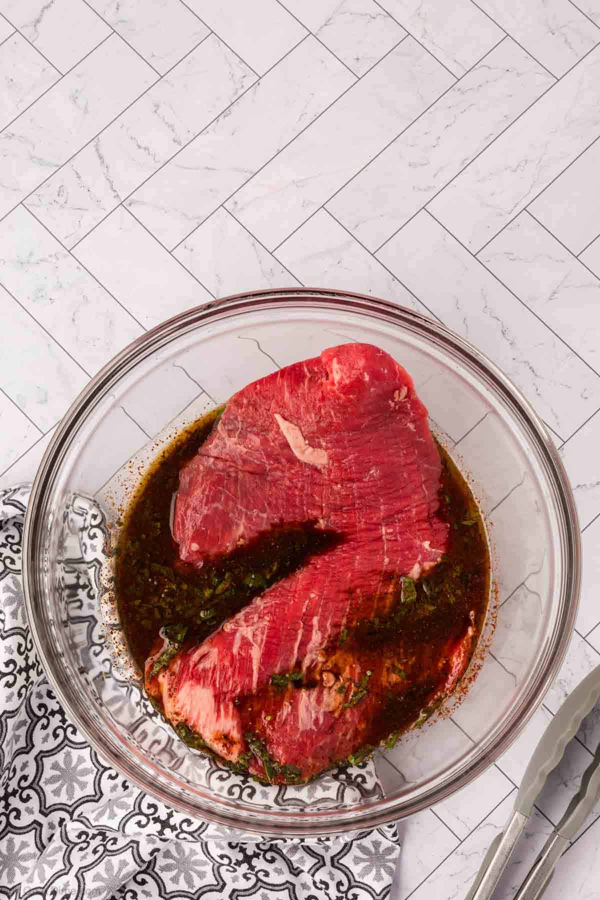 Placing the flank steak in the marinade in the bowl