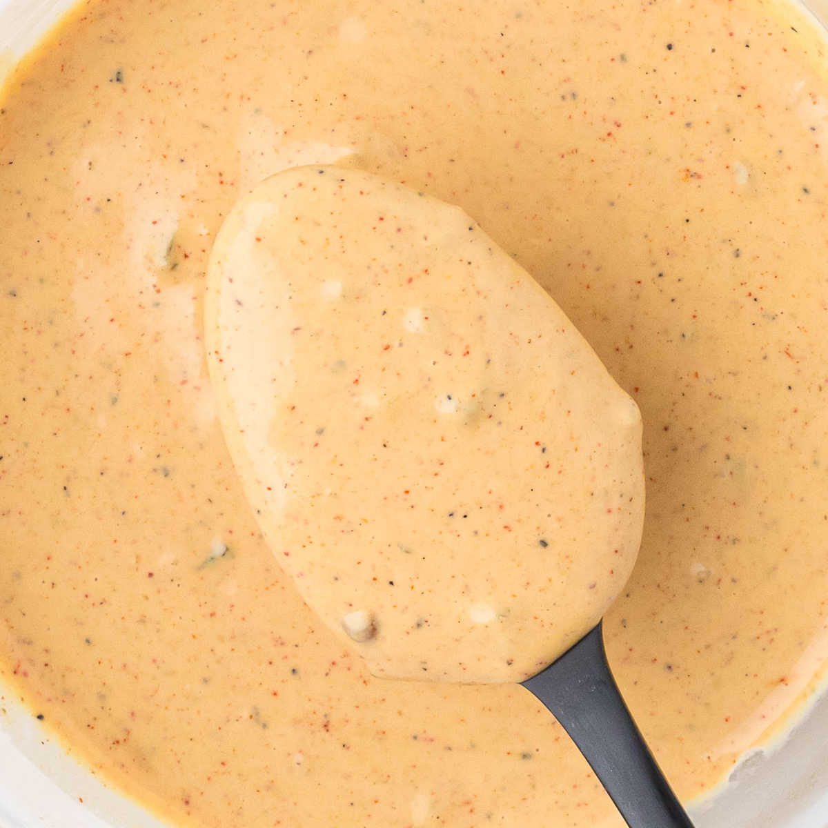 Creamy sauce with black pepper flecks, perfect for dipping or drizzling.