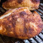 A close up of a chicken on a grill.