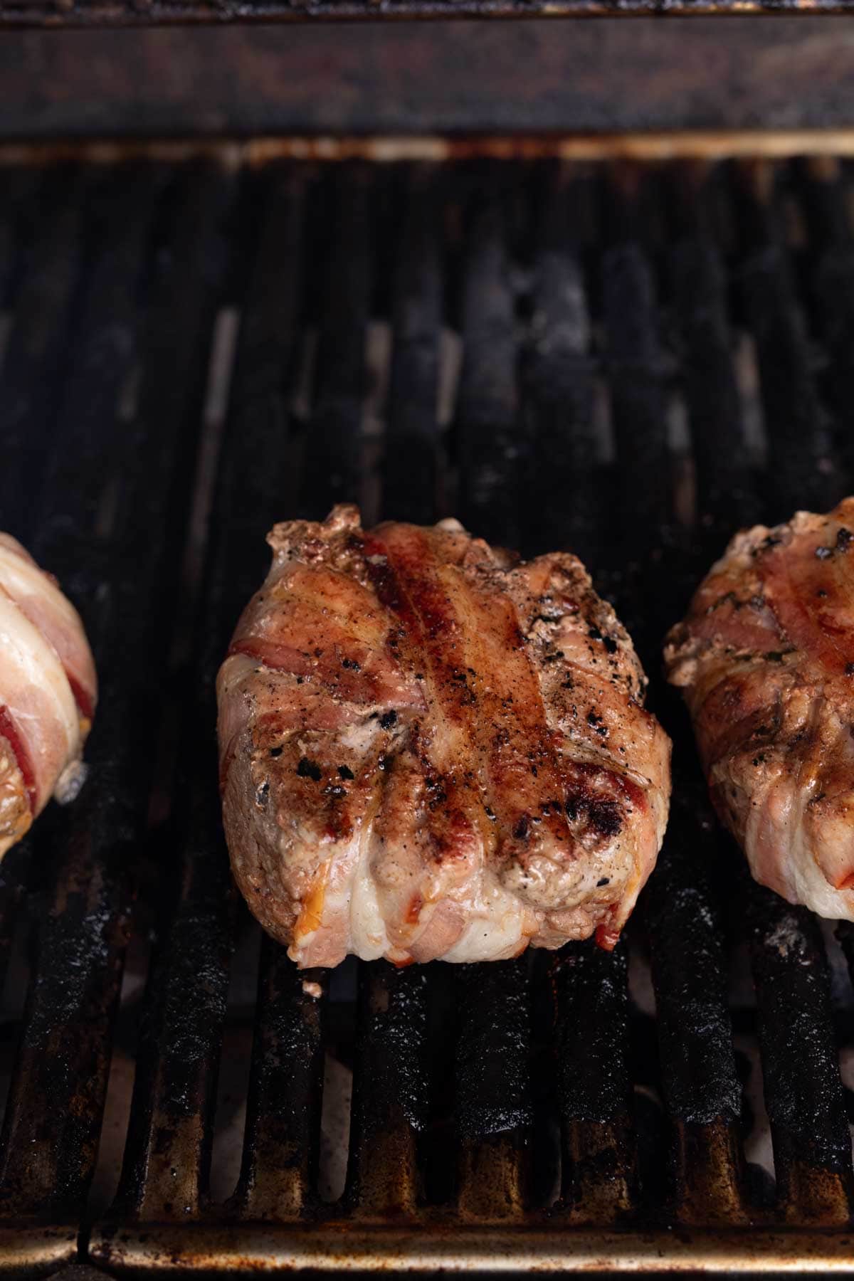 Cooked bacon wrapped burger on the grill