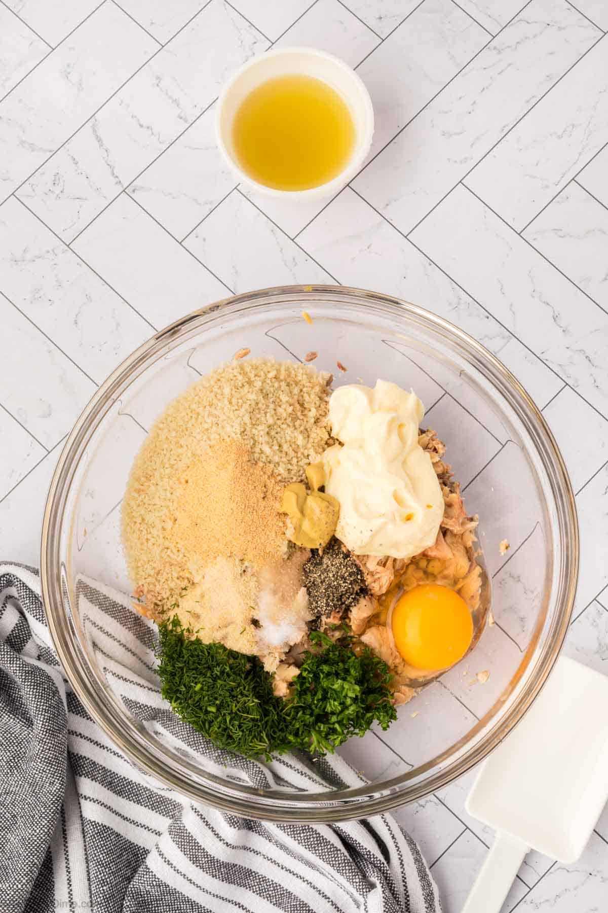 Adding the other ingredients into the bowl with the shredded salmon