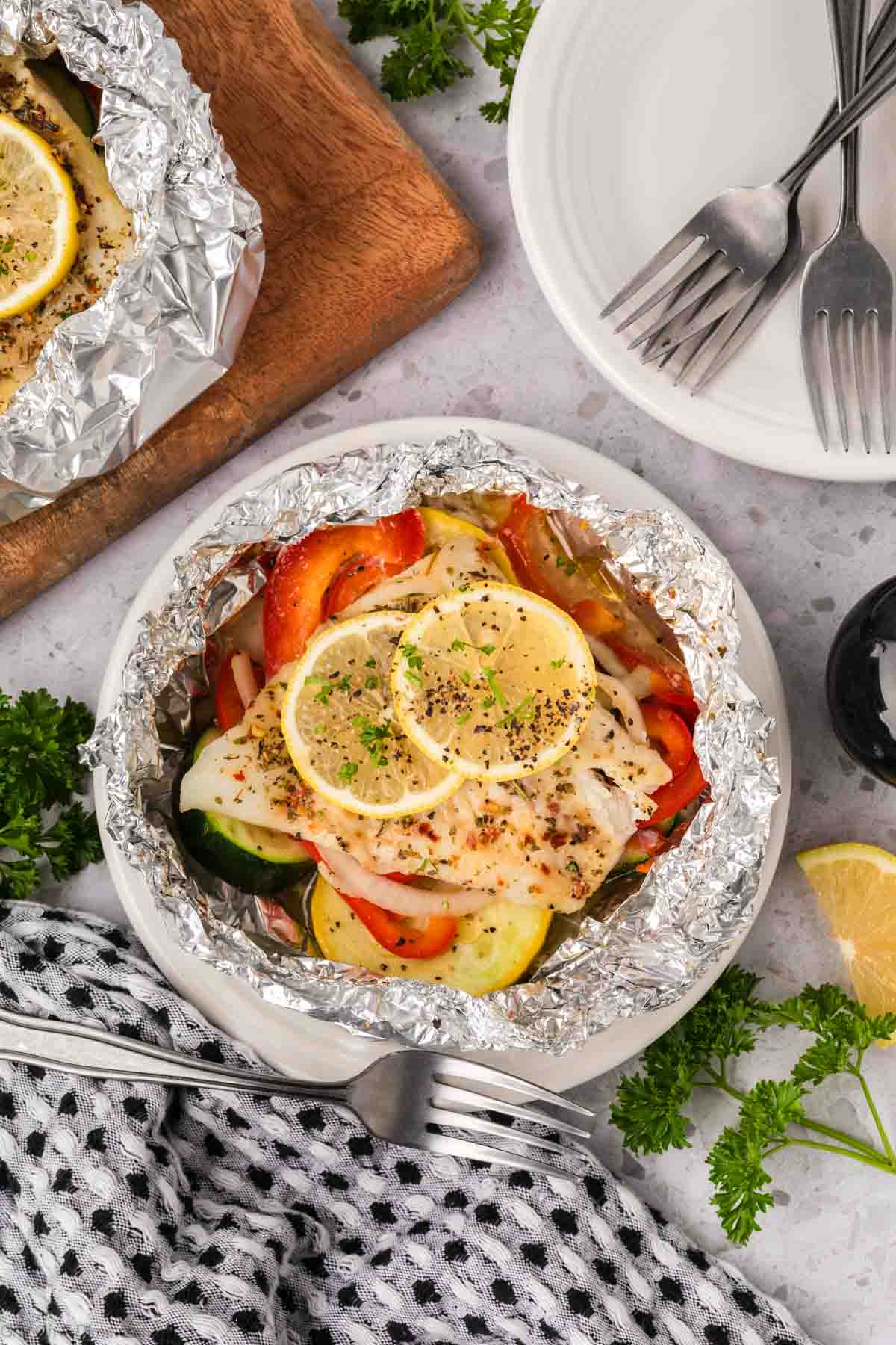Fish and veggies foil packet on plate
