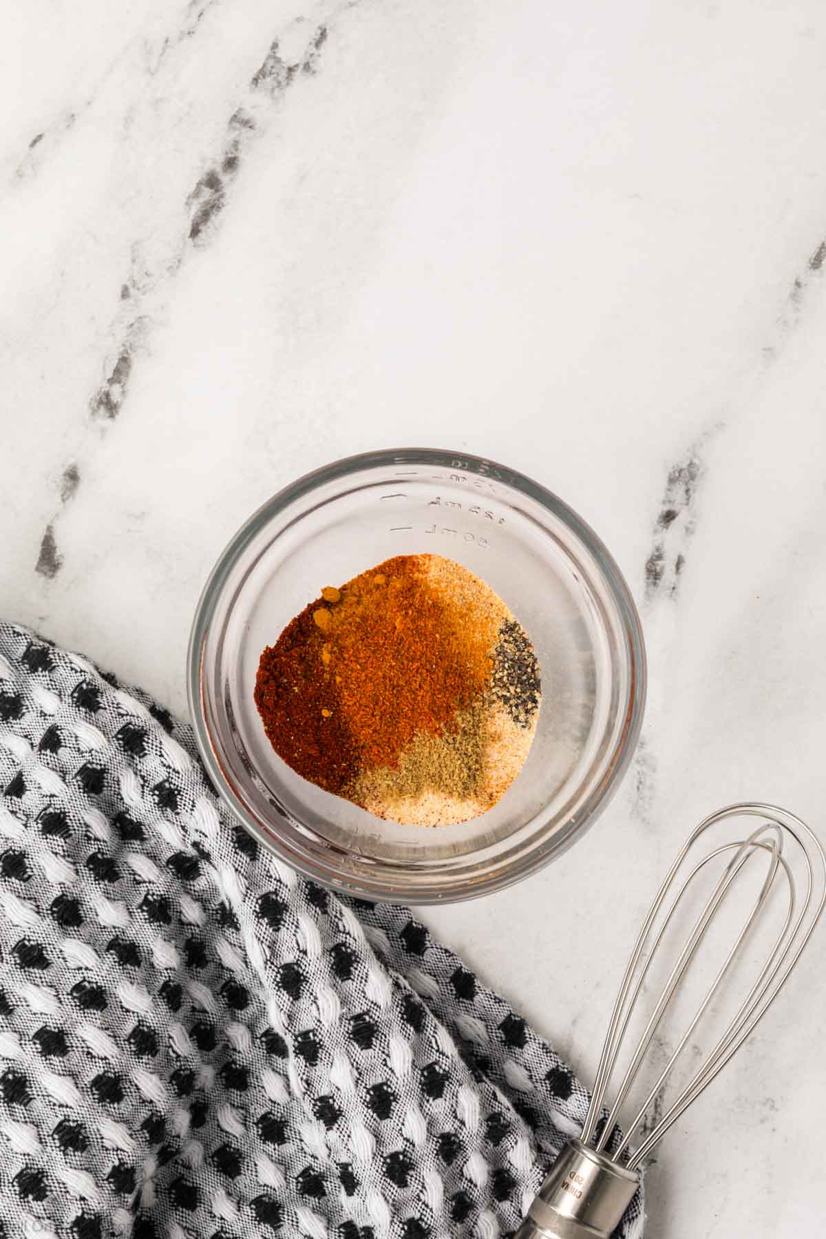 A small glass bowl filled with ground spices. 