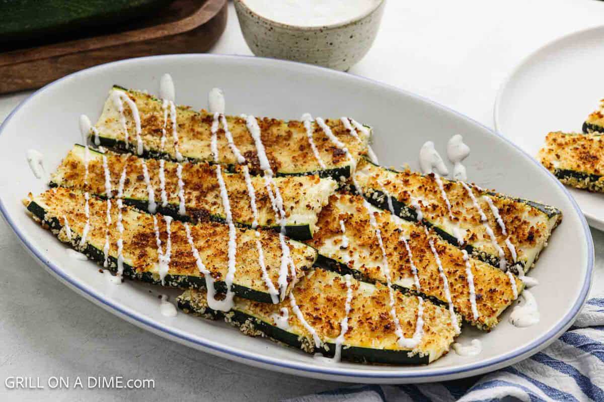 Parmesan Zucchini on a platter drizzled with ranch.