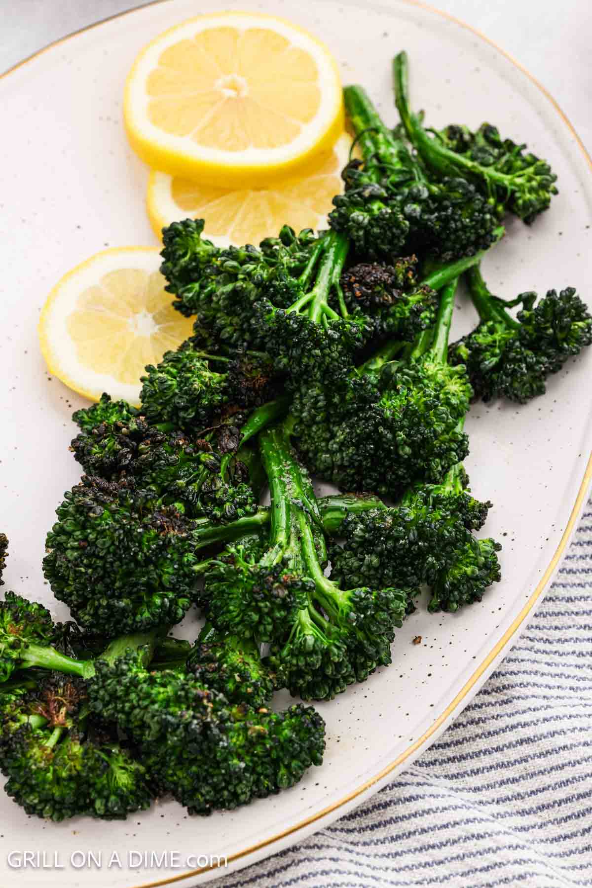 This easy grilled side dish is served on a platter with lemon slices. 