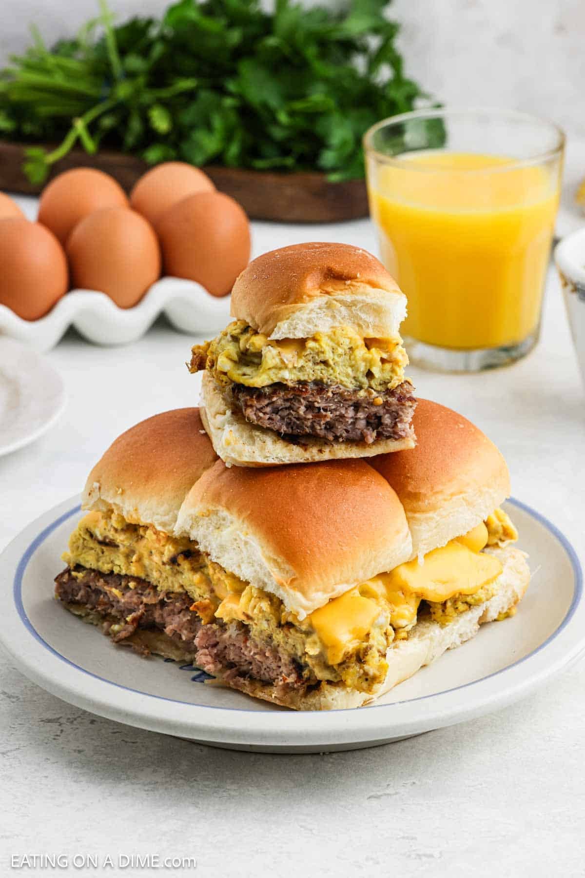 A serving of a breakfast sliders stacked on a plate. 