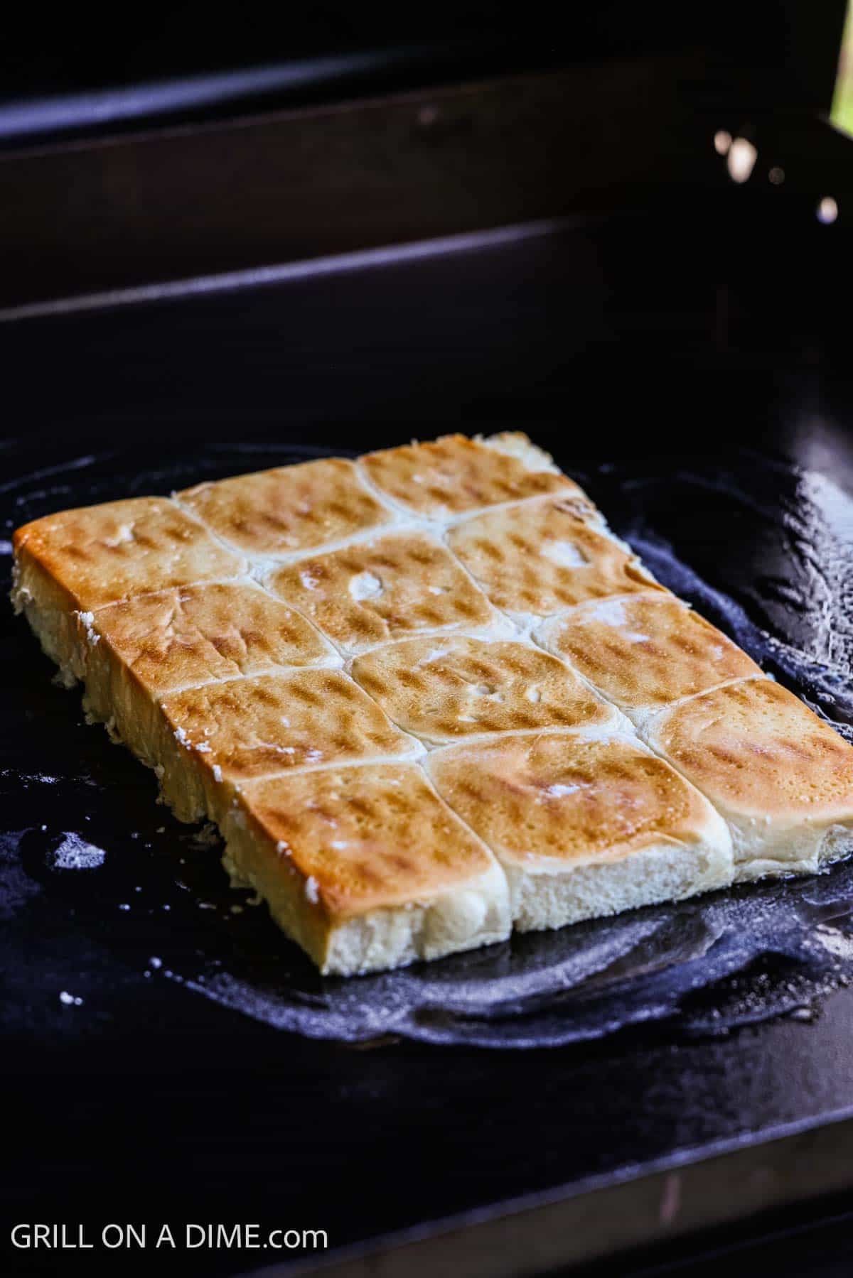 Bottom rolls placed on the melted butter on the Blackstone Griddle. 