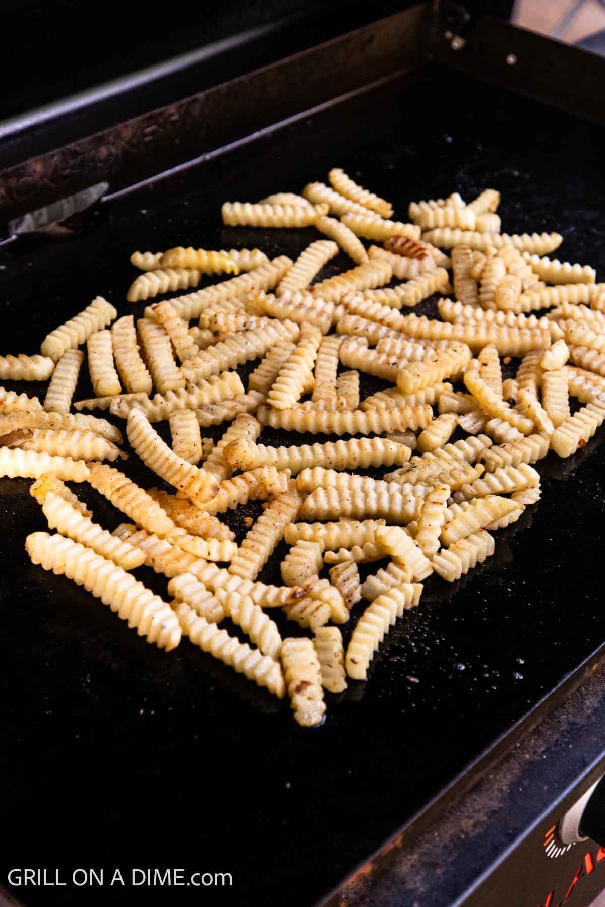 Frozen french fries on the flat top griddle. 