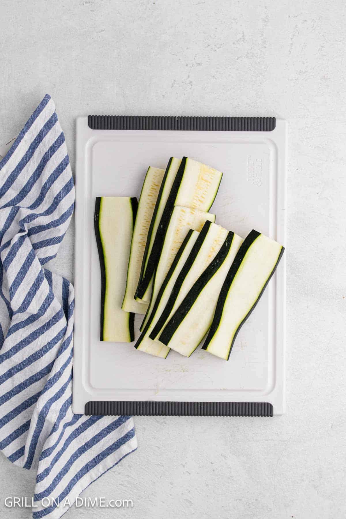 Slicing zucchini on a cutting board.