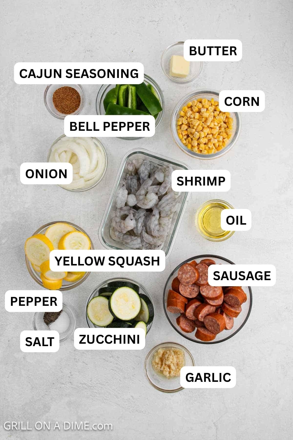 Ingredients needed for this recipe which includes shrimp, sausage, zucchini, squash, onion, corn, spices and more. 