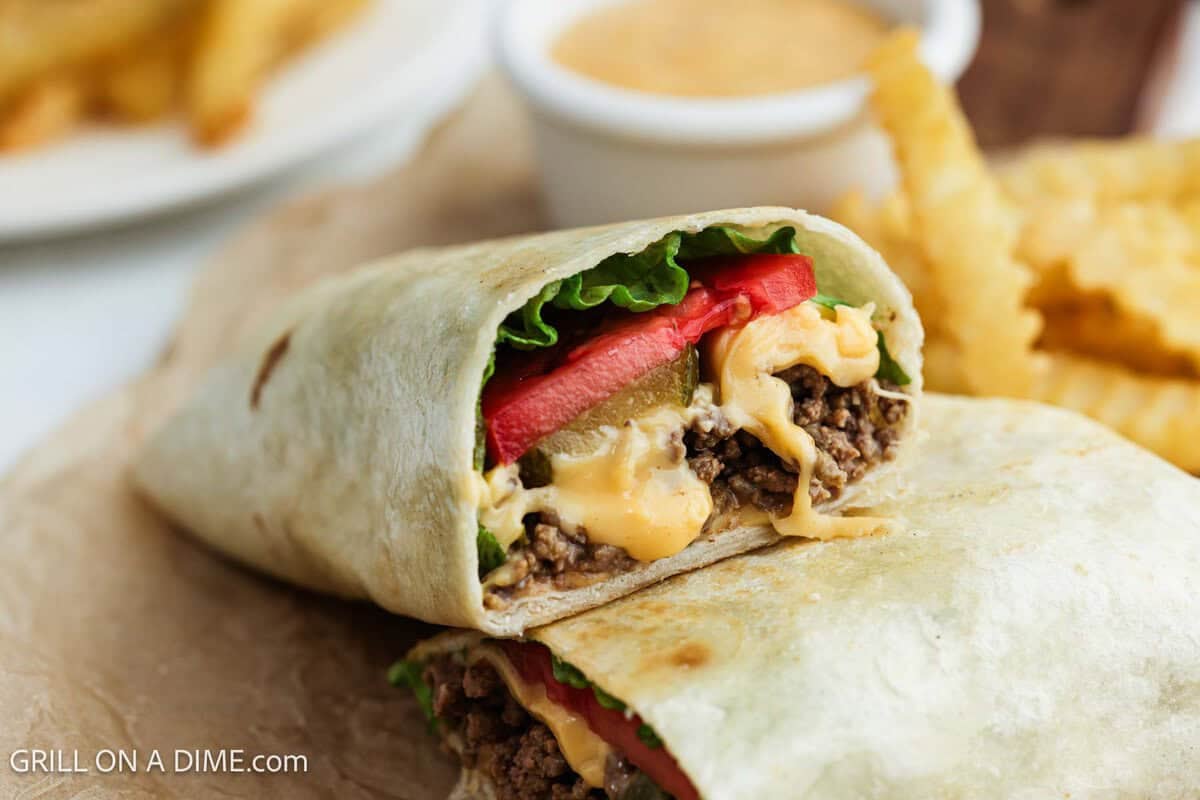 Cheeseburger wrap cut in half and stacked on a plate.