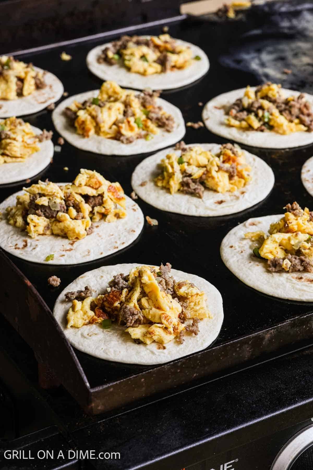 Flour tortillas topped with scrambled eggs and cooked sausage on the Blackstone Griddle. 