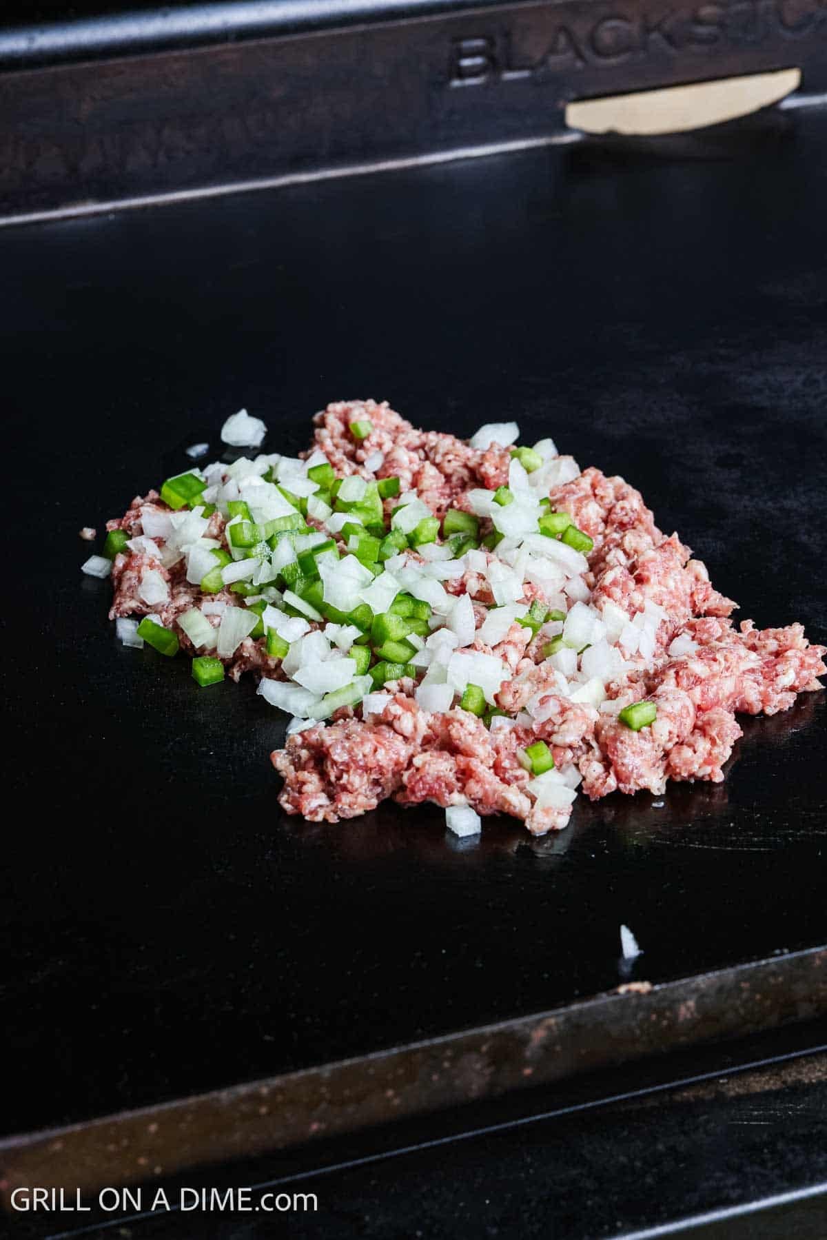 Sausage and chopped green bell pepper and onions on the Blackstone. 
